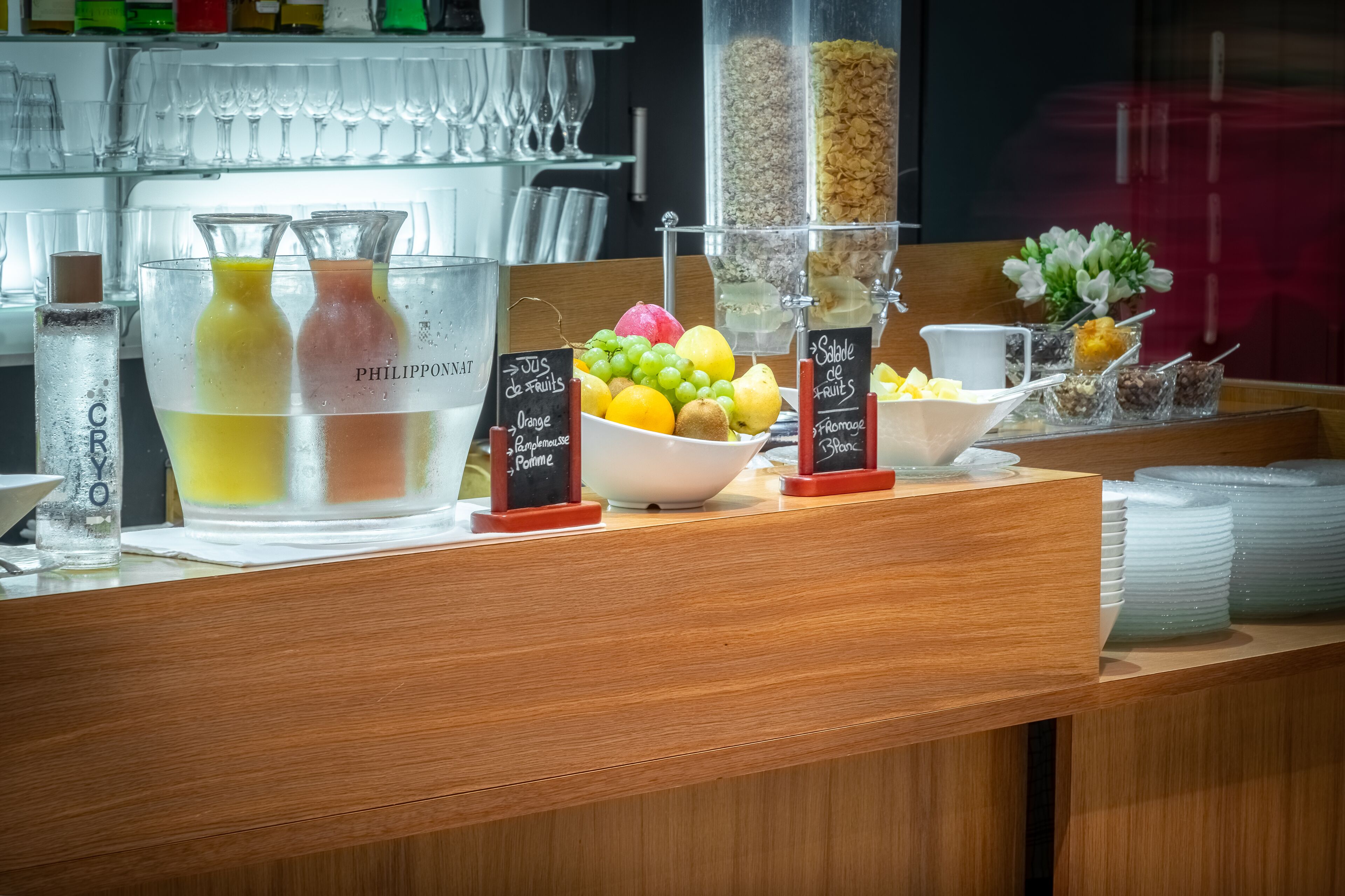 A breakfast bar with a fruit bowl, a cereal dispenser, and a glass pitcher labeled "PHILIPPONAT".