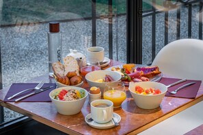 A breakfast table with croissants, fruit, eggs, and juice. - Chateau des Reynats (Chancelade)