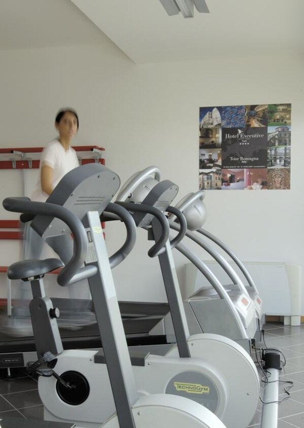 A gym with treadmills and a person walking on the treadmill.