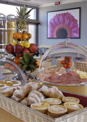A buffet with various food items including fruits, pastries, and deli meats. - Hotel Executive (Forlì)