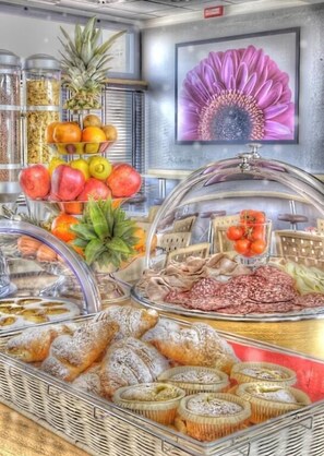 A buffet with various food items including fruits, pastries, and meats. - Hotel Executive (Forlì)