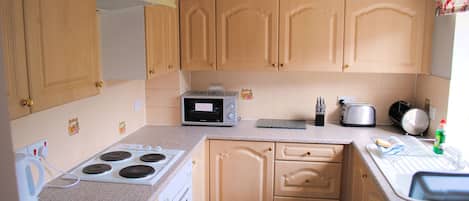 Fridge, microwave, coffee/tea maker, cookware/dishes/utensils