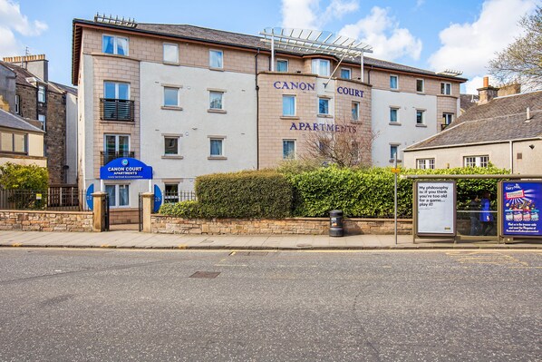 A multi-story building with the sign "Canon Court Apartments" indicating a residential complex. - Hot-el-Apartments Canon Court (Edinburgh)