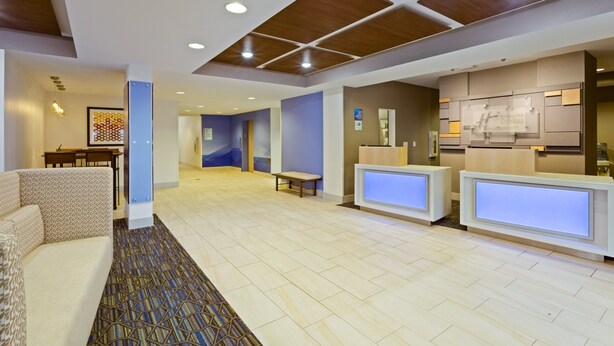 A hotel lobby with a reception desk, seating area, and a dining area. - Holiday Inn Express Hotel & Suites Tavares - Leesburg by IHG (Tavares)