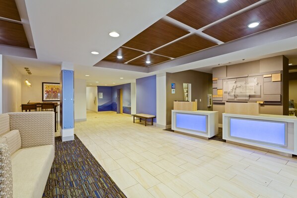 A hotel lobby with a reception desk, seating area, and a dining area. - Holiday Inn Express Hotel & Suites Tavares - Leesburg by IHG (Tavares)