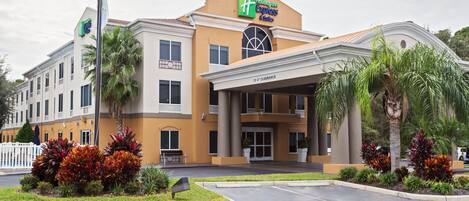Een Holiday Inn Express gebouw met een bord dat 15 voet vrije hoogte aangeeft, palmbomen en een goed onderhouden gazon.