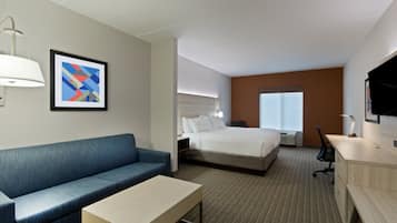 Una habitación de hotel con una cama, un sofá, un escritorio y un televisor.