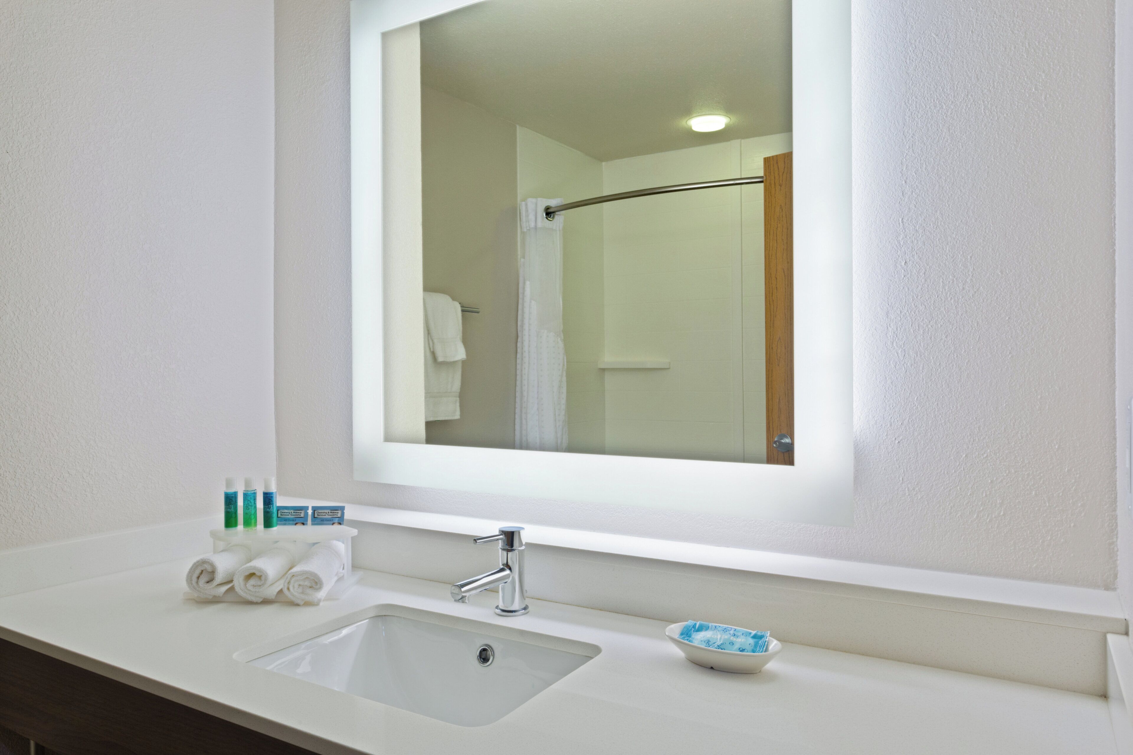 A bathroom with a white sink, a mirror, and a towel rack.