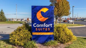A Comfort Suites sign with a crescent moon logo, surrounded by shrubs and a clear sky. - Comfort Suites Grand Rapids South (Grand Rapids)