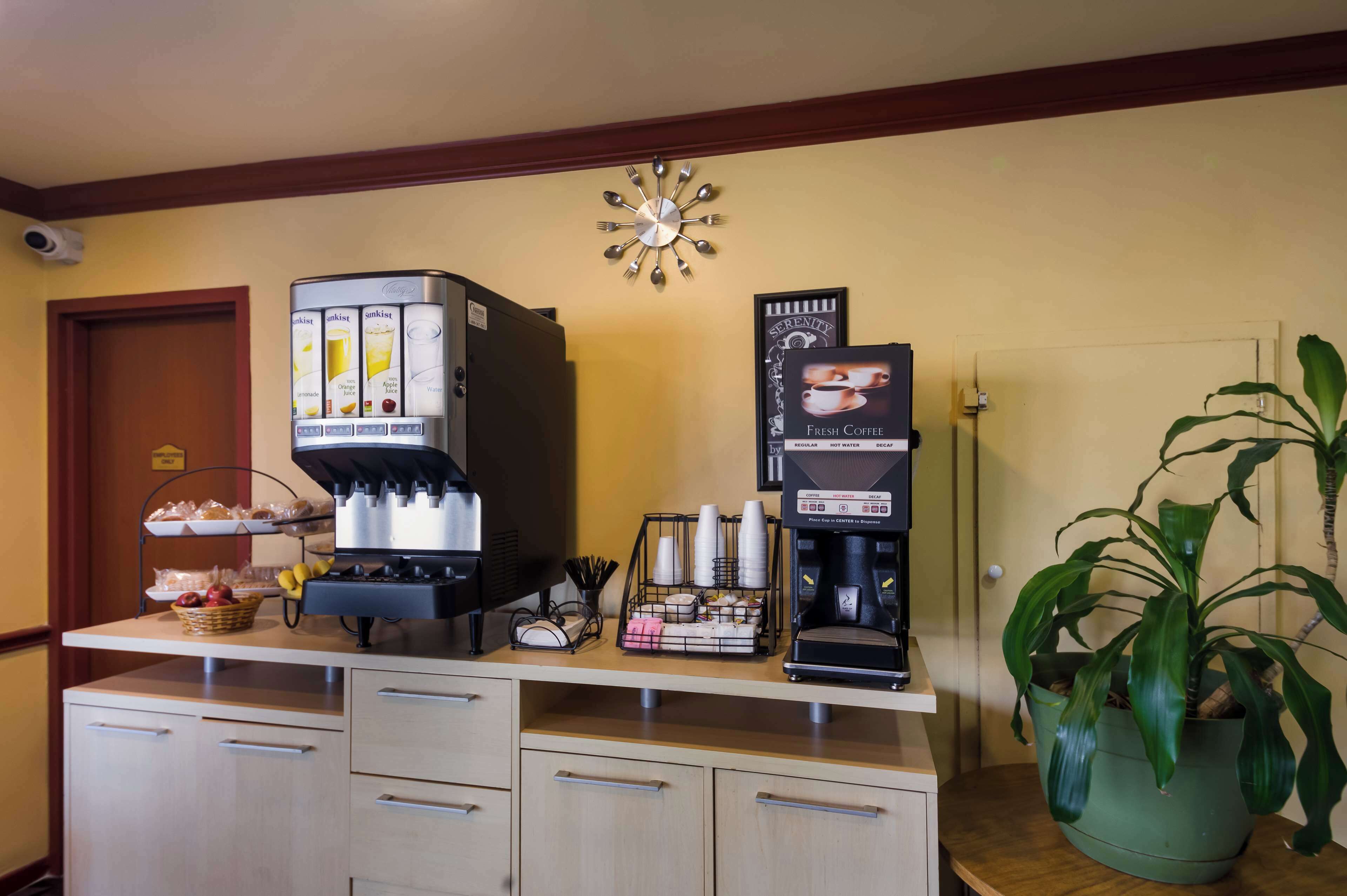En kaffestation med flera kaffebryggare och en klocka på väggen.