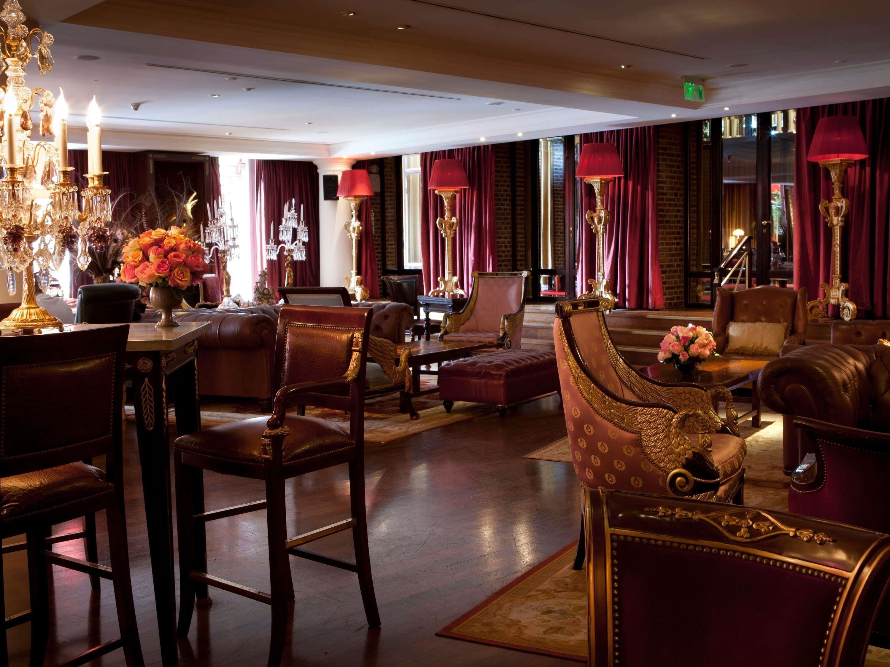 Un lobby lujoso con candelabros ornamentados, asientos cómodos y una decoración elegante.