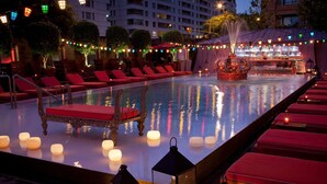 A poolside area with lounge chairs, candles, and a fountain. - Faena Hotel Buenos Aires (Buenos Aires)