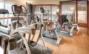 A gym with various exercise equipment including treadmills, ellipticals, and weight machines. - Club Wyndham Inn on Long Wharf (Newport)