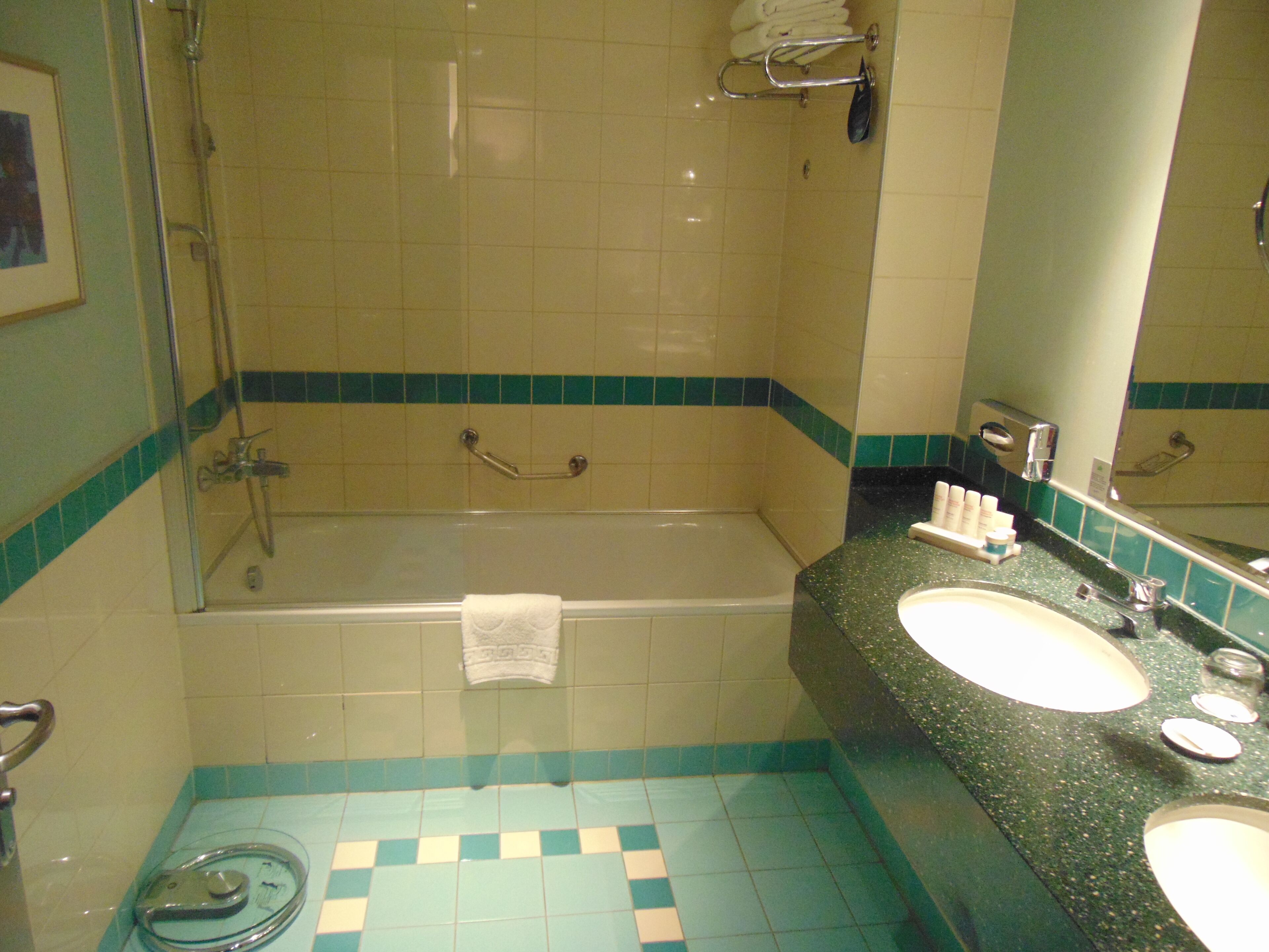 Ein Badezimmer mit Badewanne, zwei Waschbecken, einer Duschkabine aus Glas und Fliesenboden.