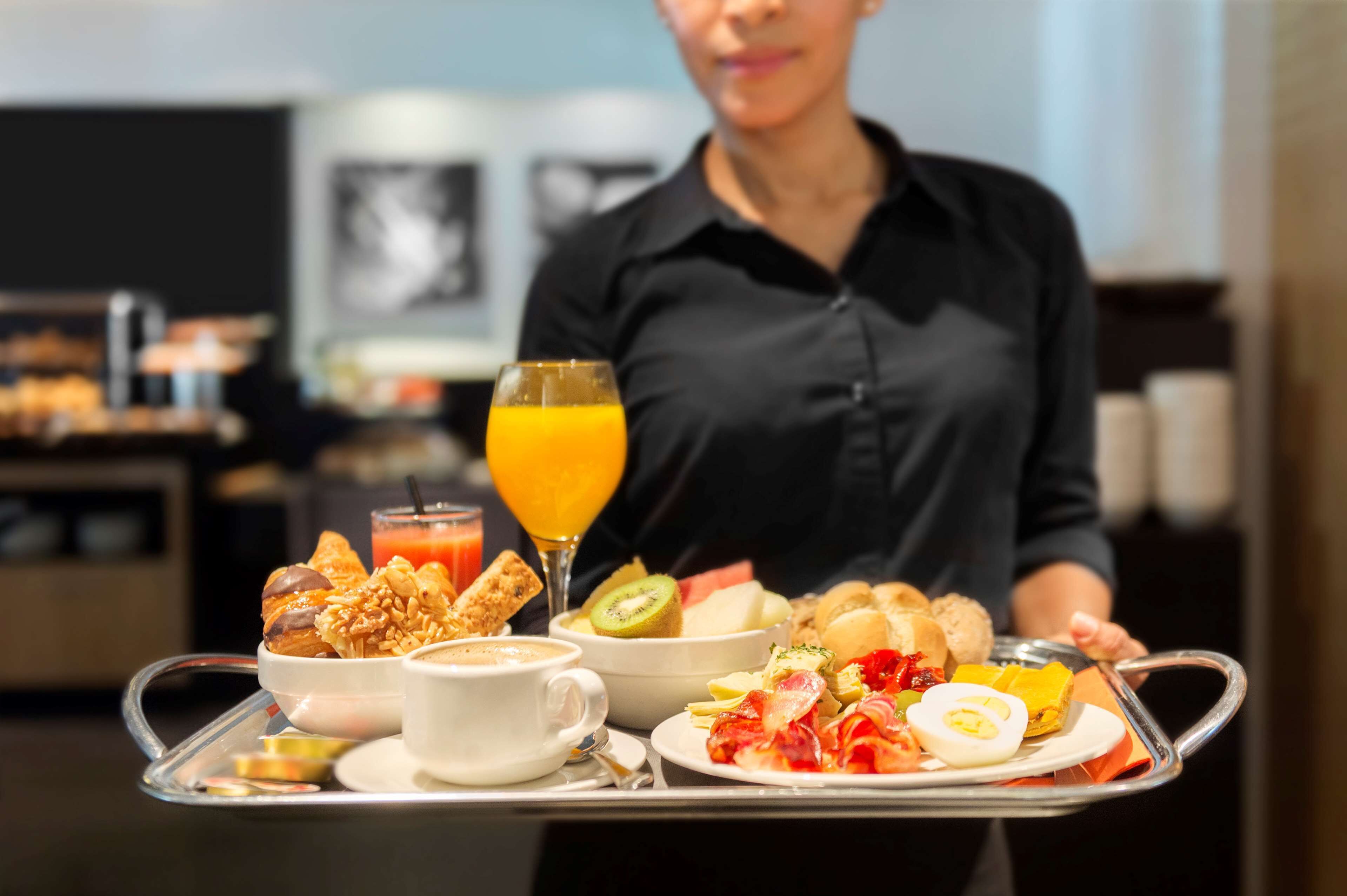 Un plateau de petit-déjeuner avec divers aliments et un verre de jus d’orange.