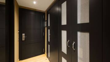 Un pasillo con puertas de madera oscura, una de ellas con un estampado a rayas verticales.