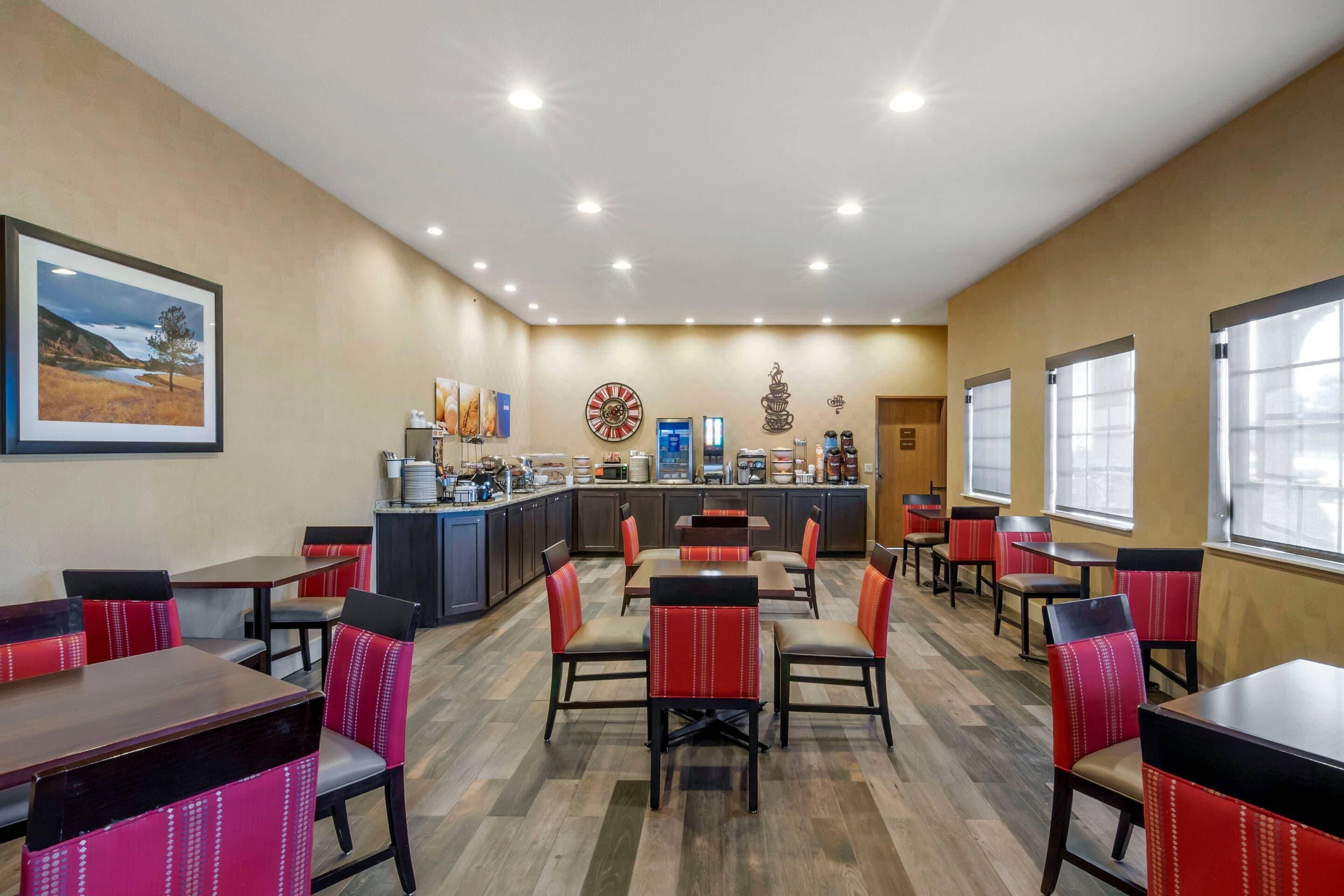 A restaurant with booths and tables, a counter with a coffee machine, and a clock on the wall.