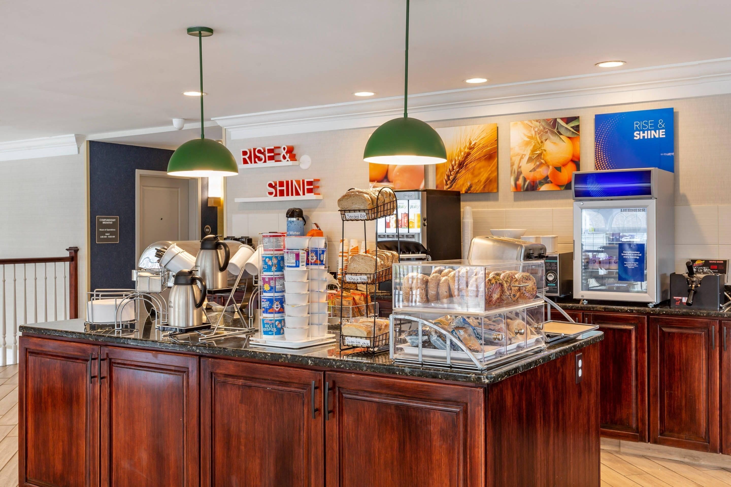 A breakfast bar with coffee machines, bread, and pastries.
