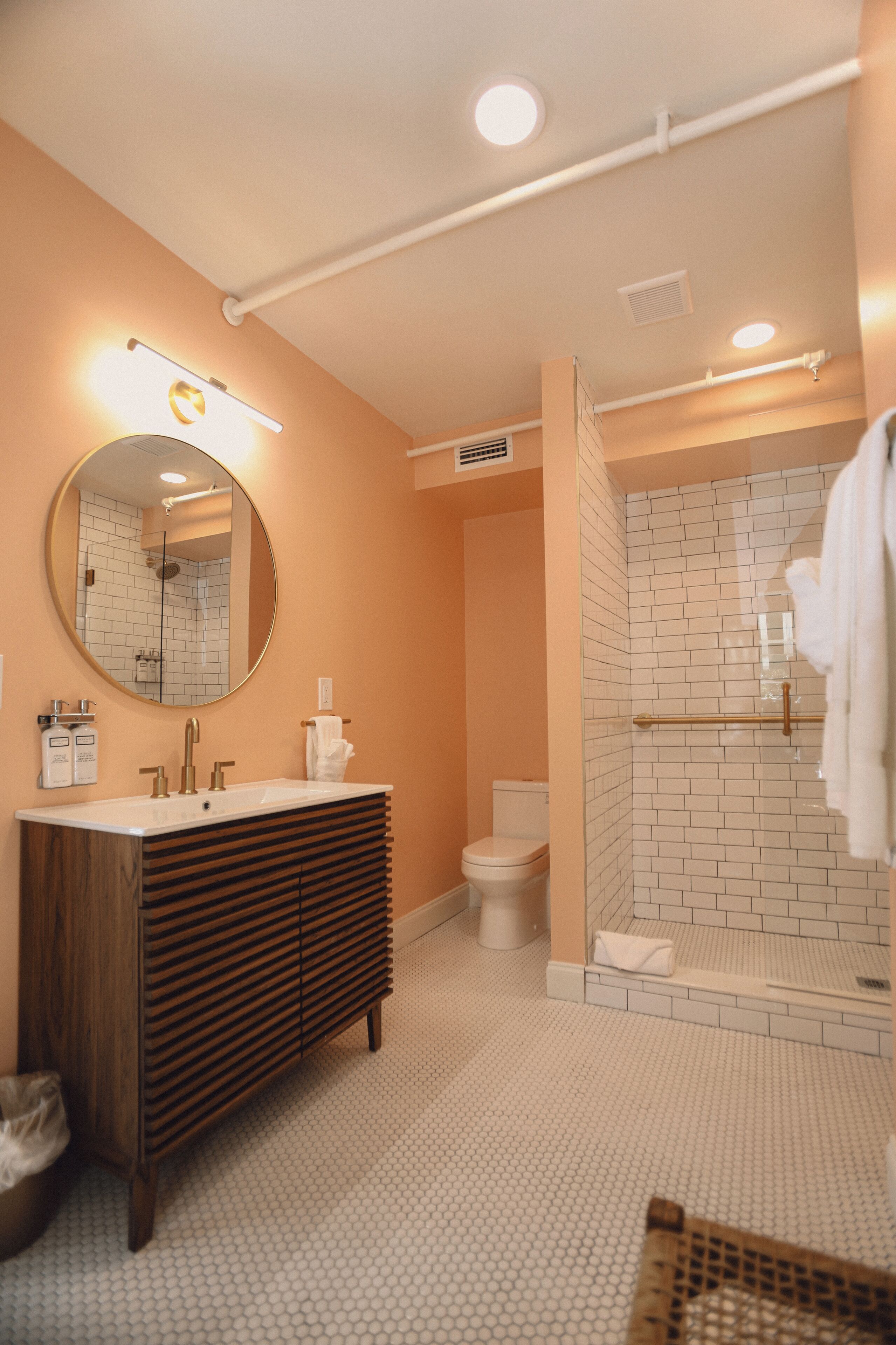 Une salle de bain moderne avec un meuble-lavabo, un évier, un miroir et un espace douche.