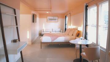 Une chambre d’hôtel avec un lit, une table de chevet, une chaise et une fenêtre donnant sur un paysage agréable.