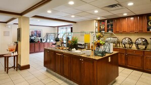 Cocina de hotel con una barra de buffet, que incluye una exhibición de frutas y una estación de bebidas.
