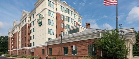 A multi-story hotel with a brick facade and a flagpole with an American flag.