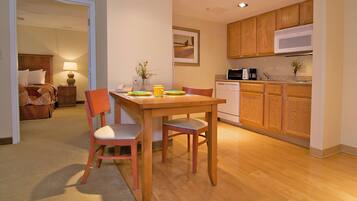 A compact living space with a dining area, kitchenette, and a bedroom.