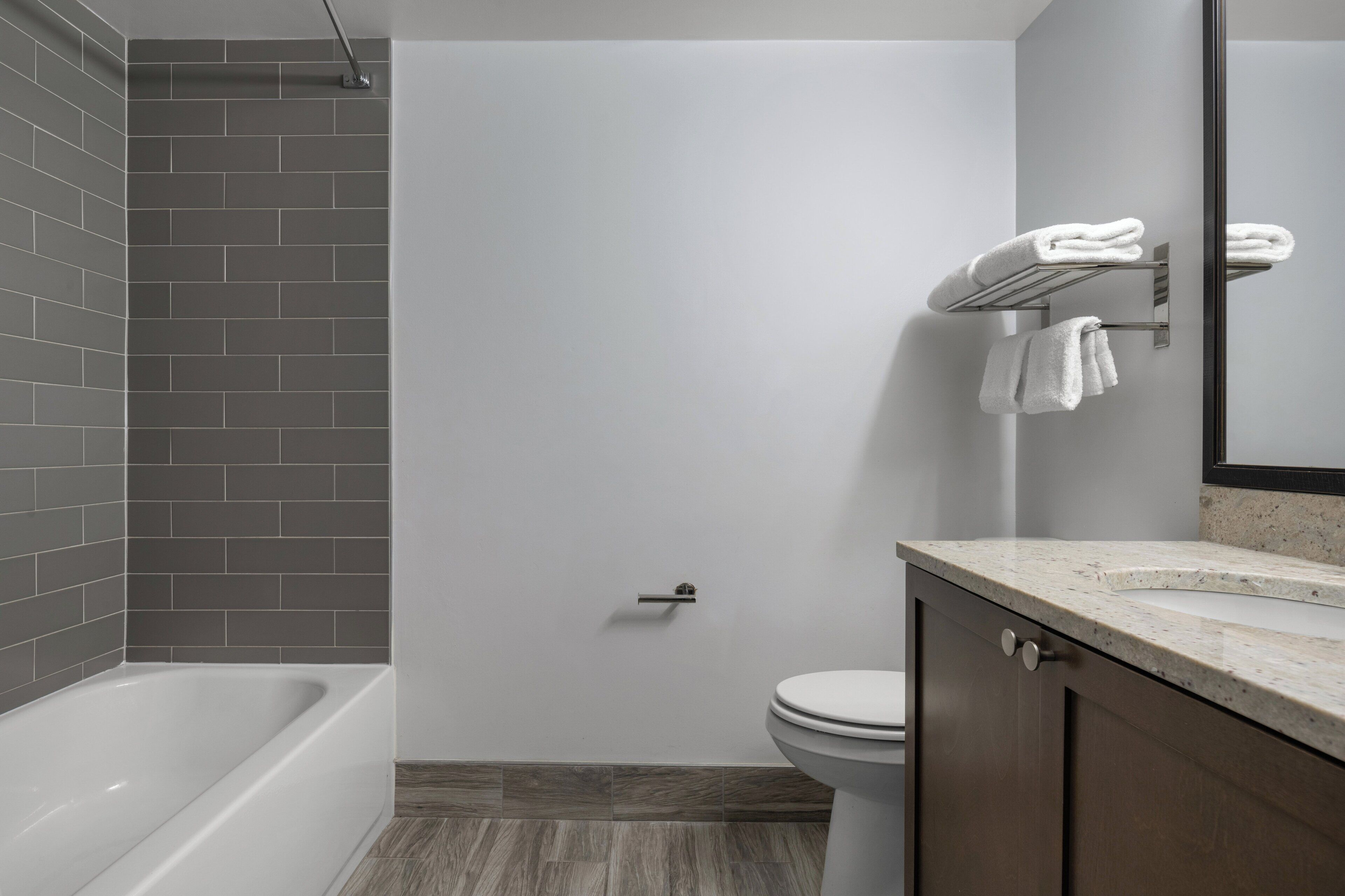 Un baño moderno con bañera, inodoro y toallero.