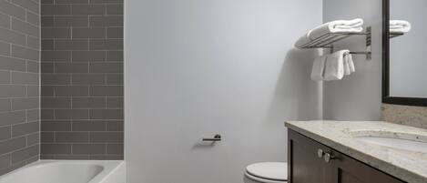 Un baño moderno con bañera, inodoro y toallero.