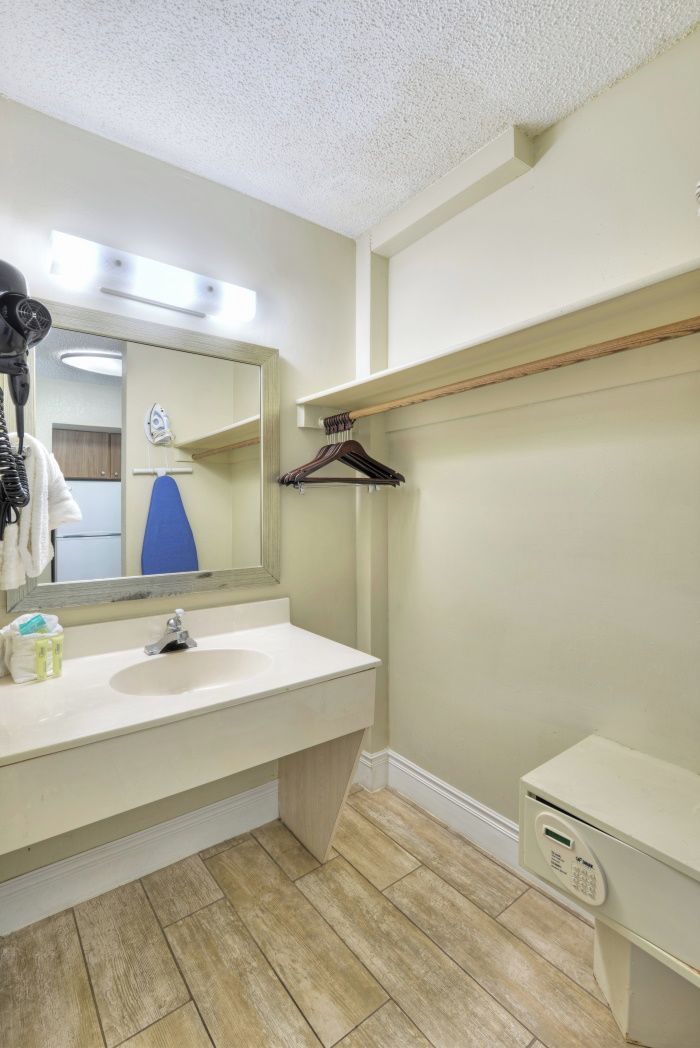 Une salle de bain équipée d’un lavabo, d’un miroir, d’un porte-serviettes et d’un petit meuble de rangement.