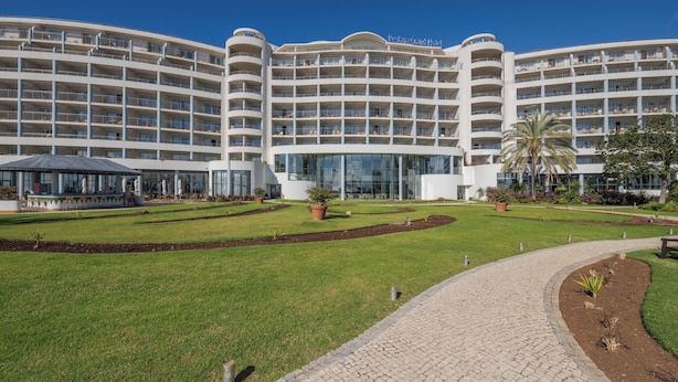 A multi-story hotel with a central courtyard, outdoor seating, and a covered area. - Pestana Grand Premium Ocean Resort (Funchal)