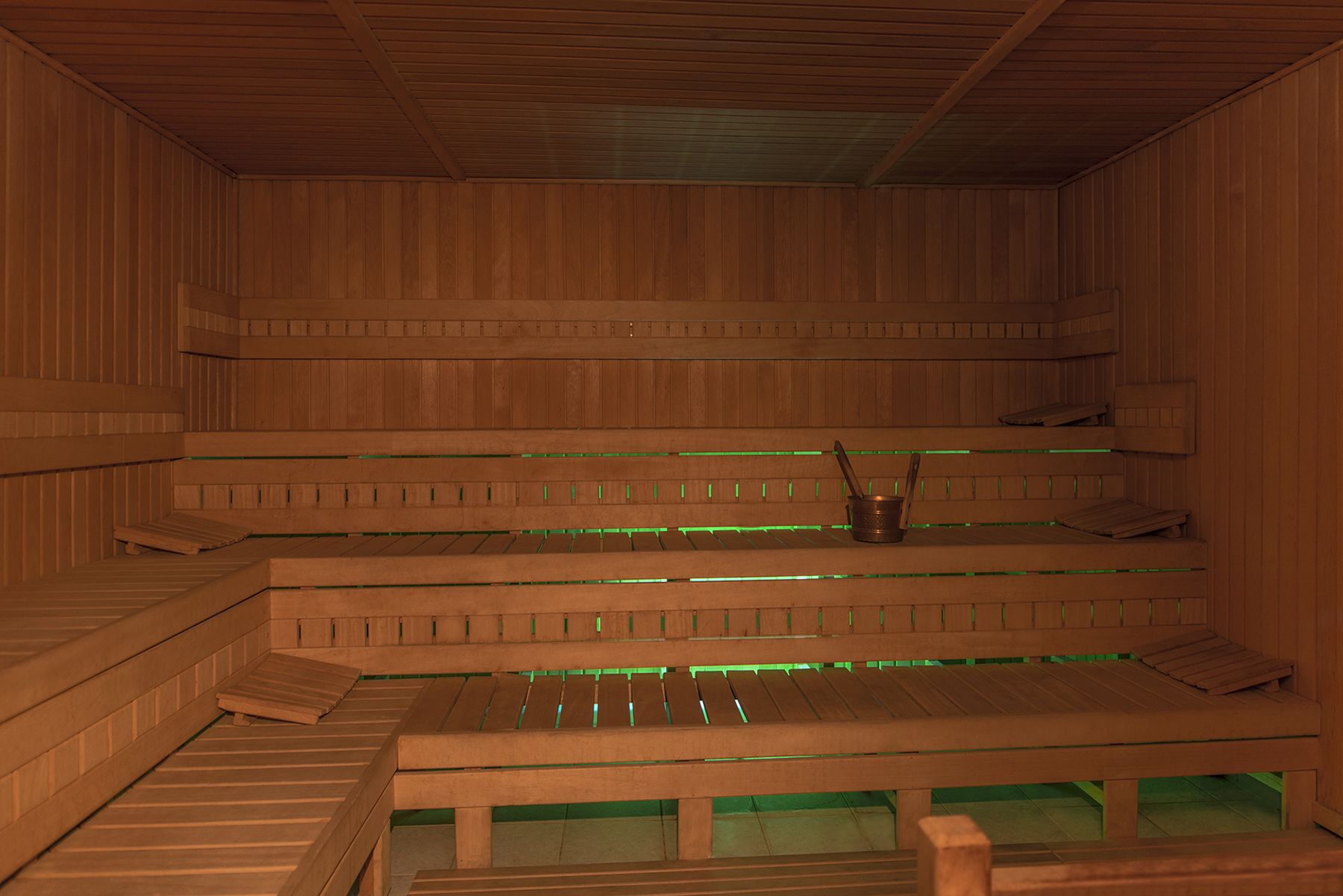 Una sauna con bancos de madera y un elemento calefactor central.