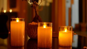Three lit candles on a reflective surface.