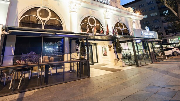 Un hôtel reconnaissable à son grand panneau « HOTELLICKALE », à ses larges fenêtres en arc de cercle et à sa façade moderne.