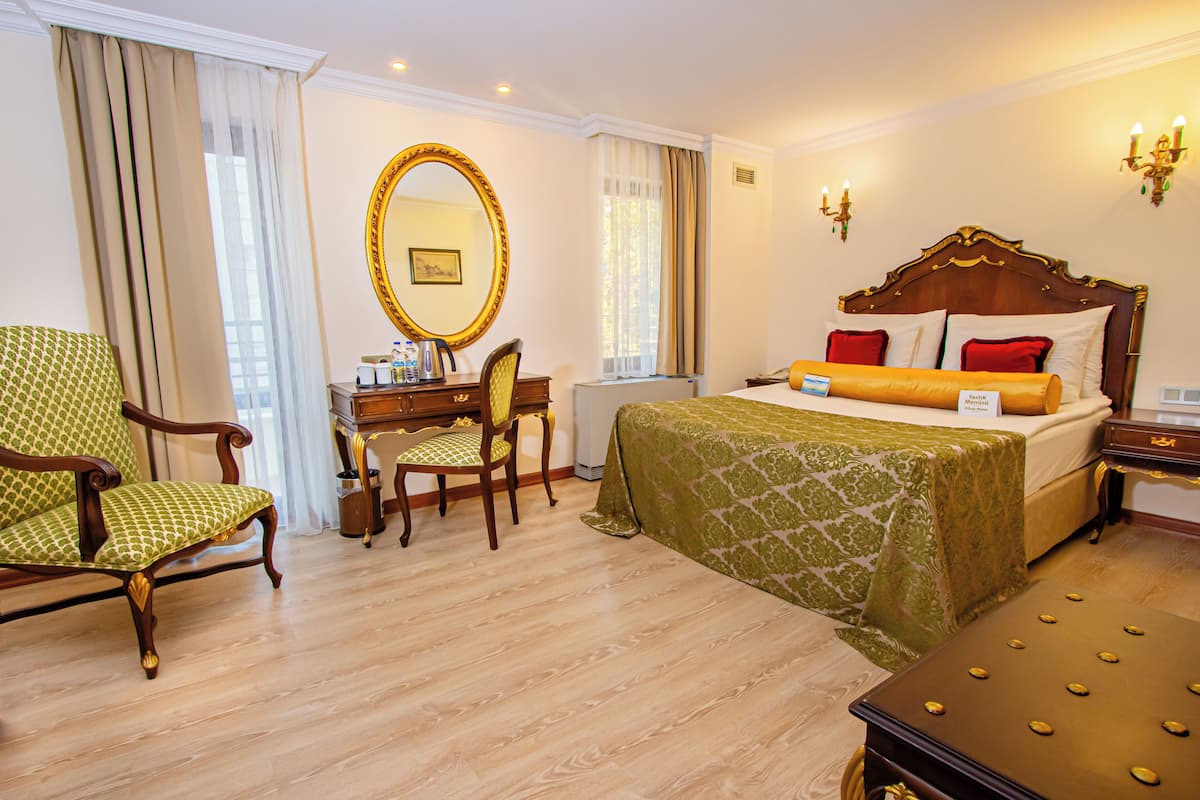 Una habitación de hotel con una cama, un escritorio, una silla, un aparador y un espejo grande.
