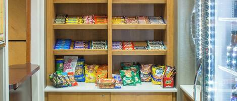 A snack vending machine with a variety of snacks and a refrigerated section.