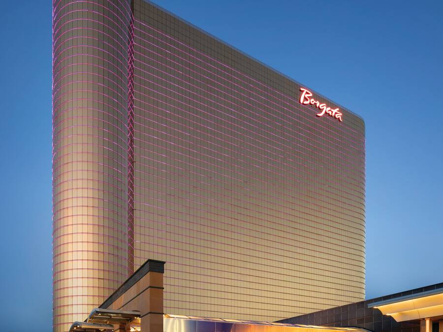 A large hotel building with a prominent 'Borgata' sign, featuring a modern architectural design with a curved facade and a well-lit entrance.