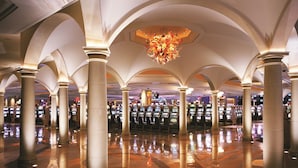 A spacious casino interior with multiple gaming machines, arched ceilings, and a central chandelier. - Borgata Hotel Casino & Spa (Atlantic City)