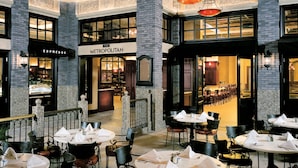 A spacious indoor dining area with multiple tables and chairs, a visible restaurant named 'METROPOLITAN', and a bar area with a counter. - Borgata Hotel Casino & Spa (Atlantic City)