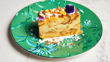 A slice of cake on a green plate with a floral pattern.