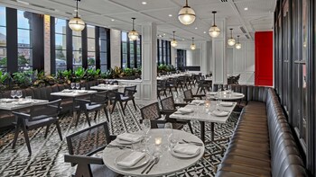 A conference room with a long table, black chairs, and potted plants. at Kimpton Hotel Fontenot by IHG