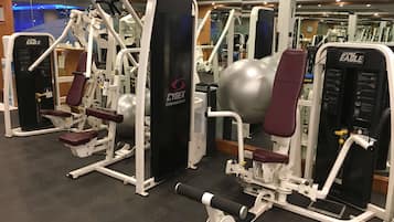 Un gimnasio con equipamiento Cybex, que incluye máquinas de pesas y una máquina de remo.