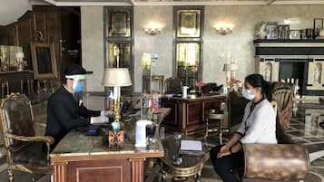 Un lobby lujoso con decoración elaborada, una recepción y zonas de estar.