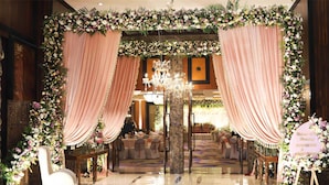 A formal event space with a floral archway, chandeliers, and a polished floor. - Radisson Blu Hotel Noida (Noida)
