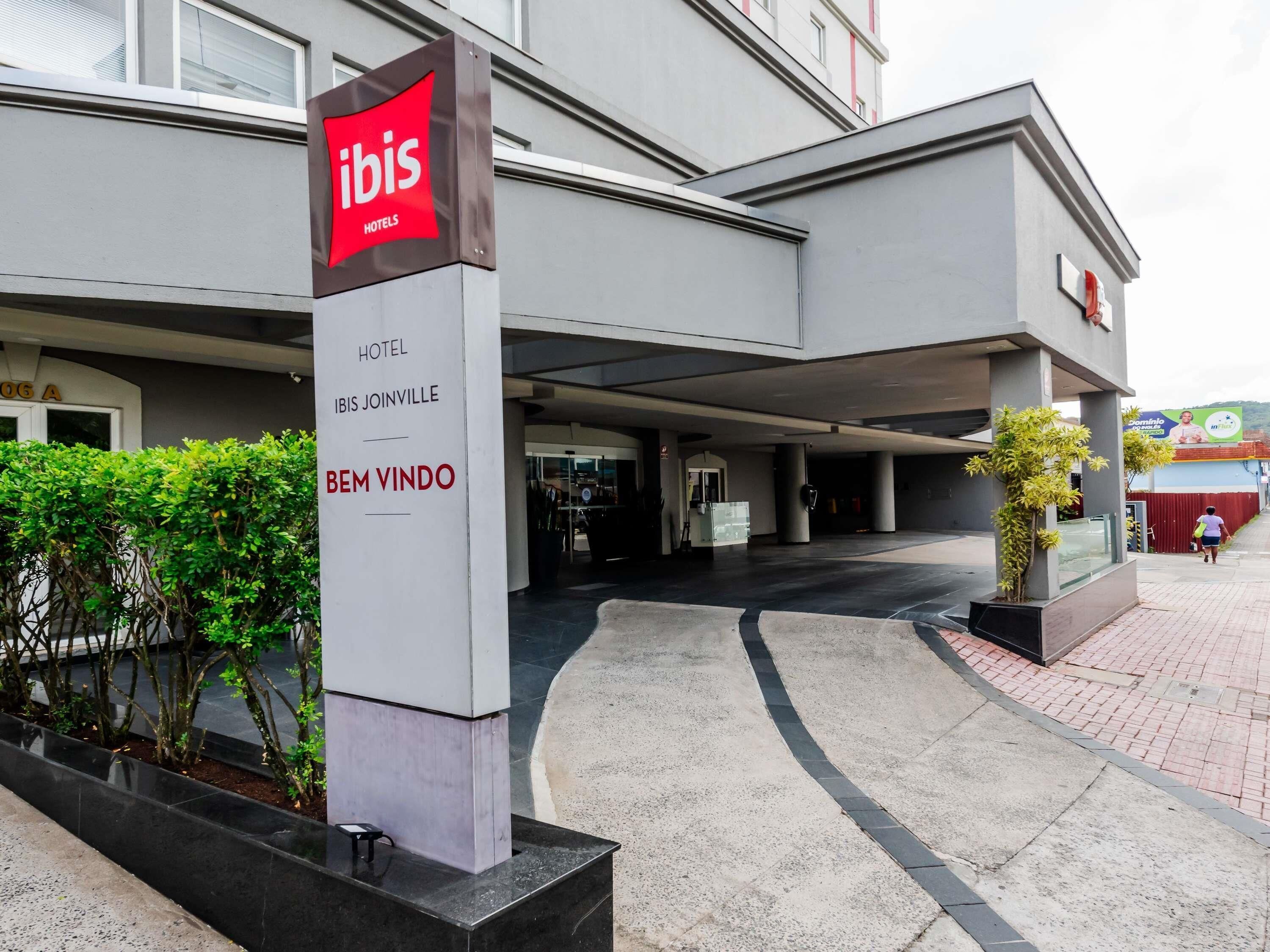 The exterior of a hotel with a prominent sign reading 'ibis HOTELS' and 'IBIS JOINVILLE'.