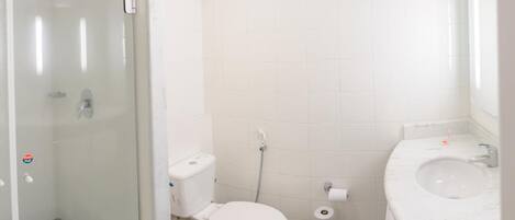 A bathroom with a toilet, bidet, and sink.