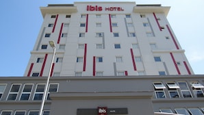 A tall hotel building with a sign reading "ibis HOTEL" at the top. - ibis Joinville (Joinville)