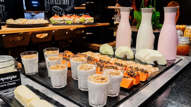 A buffet with various food items and beverages, including sandwiches, desserts, and milkshakes. - ibis Joinville (Joinville)