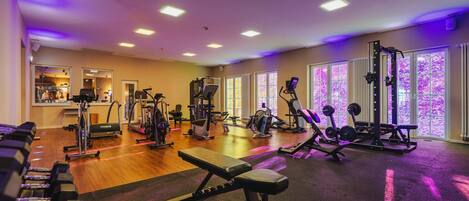 A gym with various exercise equipment, including treadmills, weight machines, and free weights.