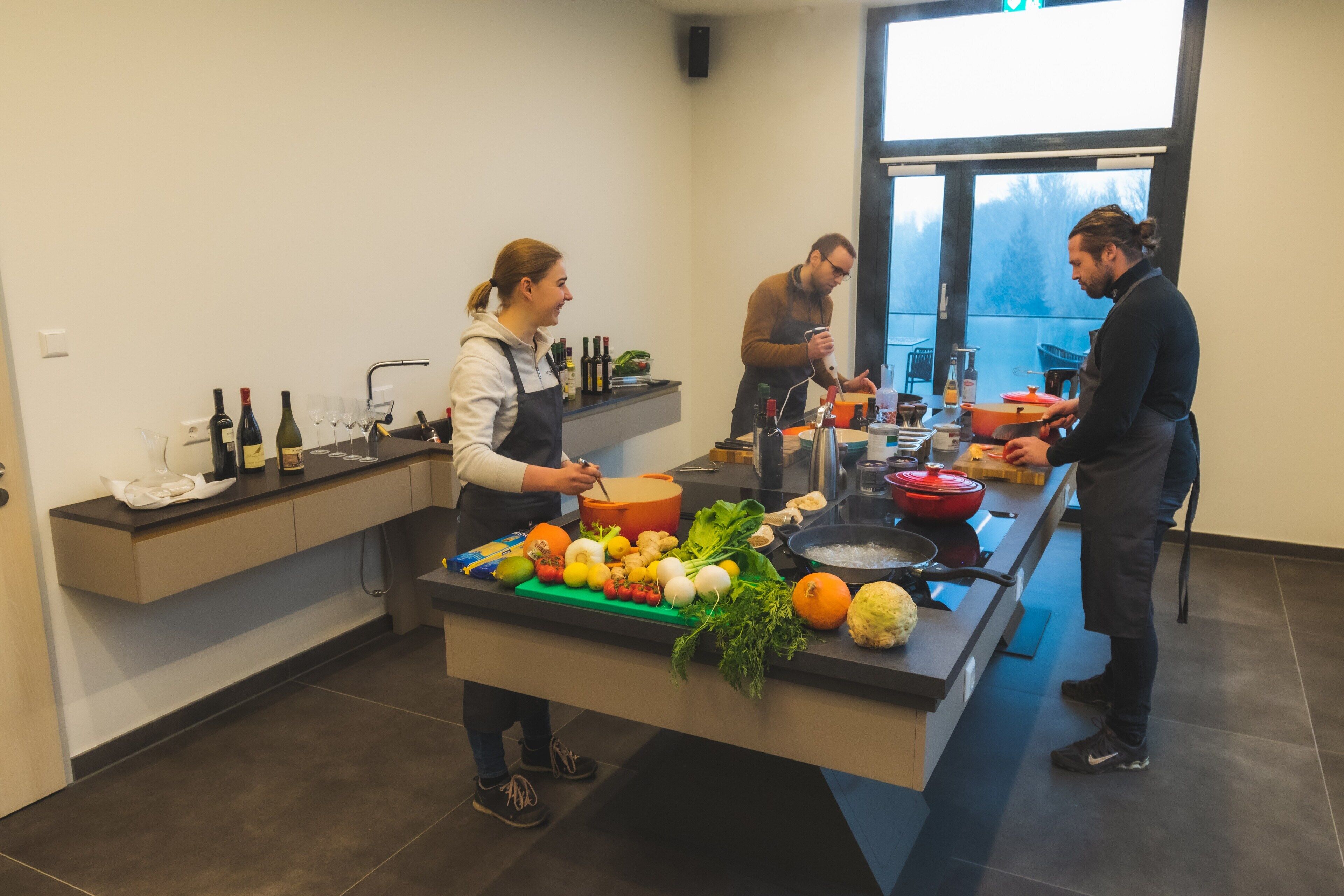 Une cuisine moderne dotée d’un îlot central, de divers ustensiles de cuisine et de produits frais.